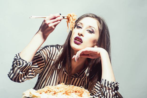 Girl eat pasta dish with tomato ketchup. Girl have italian food meal - 写真・画像