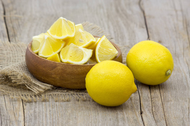 свіжі лимони в мисці на дерев'яному фоні
 - Фото, зображення