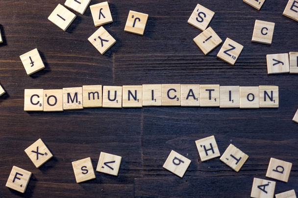 communication word made with scrabble letters on a black wooden table. - 写真・画像