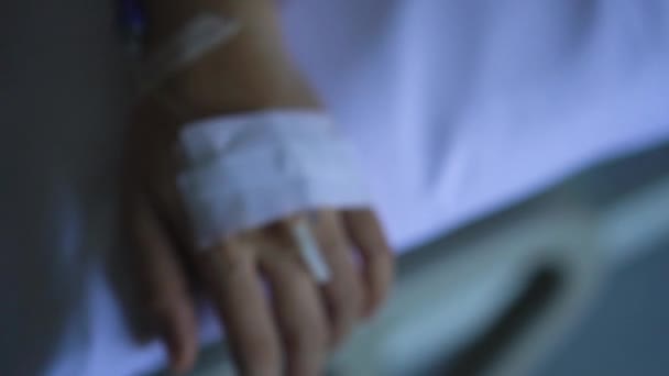 Cropped footage of female patient hand receiving saline solution drop intravenous injection - Felvétel, videó