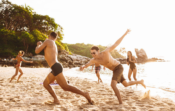 Grupo de amigos se divertindo na praia em uma ilha solitária
 - Foto, Imagem