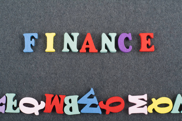 FINANCE word on black board background composed from colorful abc alphabet block wooden letters, copy space for ad text. Learning english concept - Photo, image