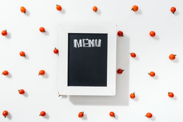 vista superior de tábua de giz com letras de menu entre tomates cereja
 - Foto, Imagem