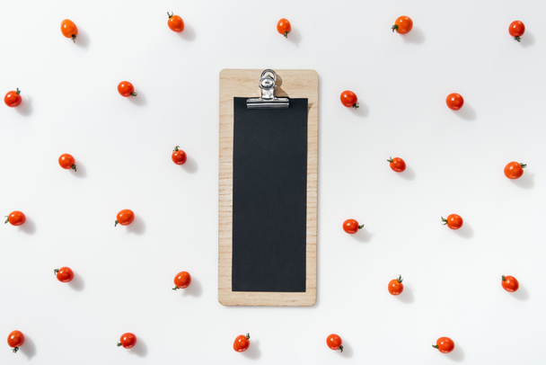 top view of empty clipboard with cherry tomatoes on white background  - Photo, Image