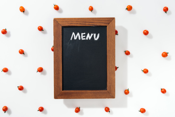 top view of chalk board with menu lettering among cherry tomatoes - Photo, Image