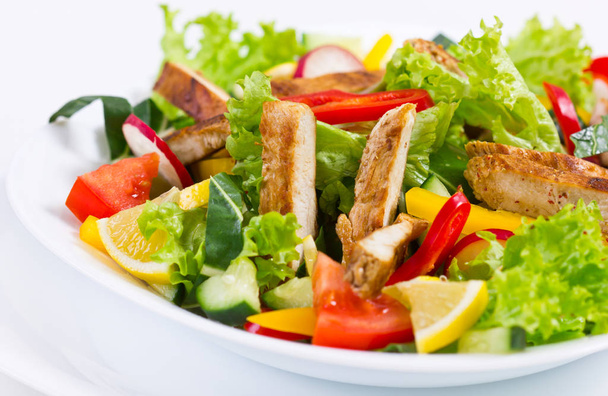 Close-up uitzicht op de zelfgemaakte salade op een witte achtergrond - Foto, afbeelding
