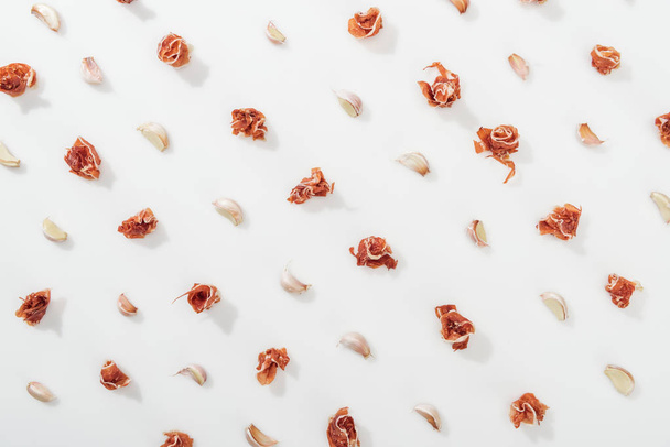 top view of prosciutto and garlic cloves on white background - Photo, Image