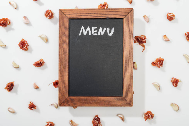 top view of chalk board with menu lettering among prosciutto and garlic cloves - Photo, Image