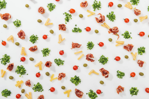 top view of olives, prosciutto, greenery, cut cheese and cherry tomatoes - Foto, afbeelding