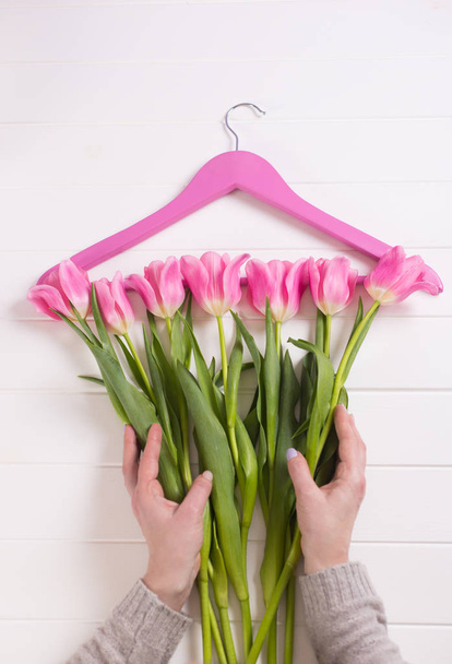 Női kezek pályázati rózsaszín tulipán, a fehér asztal, fogas, felülnézet elrendezéséhez. Tavaszi divat fogalma. - Fotó, kép