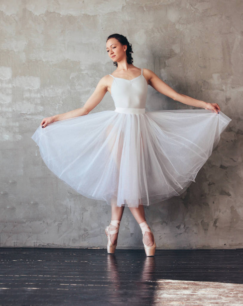 Ballet dancer ballerina in beautiful light blue dress tutu skirt posing in loft studio - 写真・画像