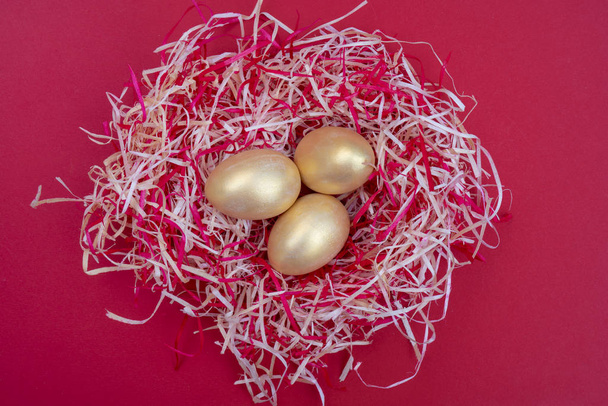 Golden Easter eggs in nest on colorful background - Photo, Image