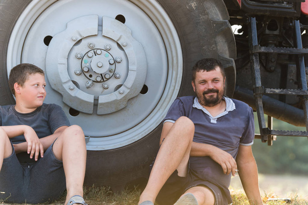 Father and son taking a break after hard work at fields - Foto, immagini