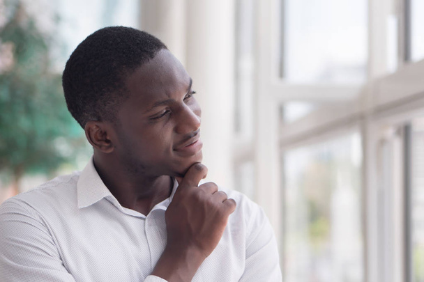Thoughtful African man thinking; portrait of pensive young adult african man thinking or planning; good idea, future, brain storming concept; African young adult black man model - Foto, Bild