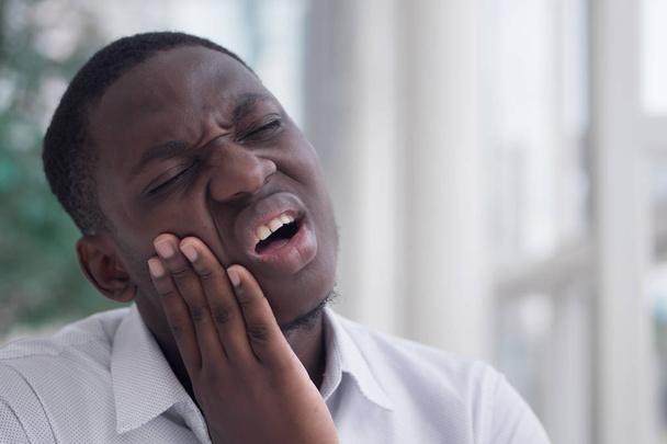 Homem africano com dor de dente; retrato do homem negro que sofre de dor de dente, cárie dentária, sensibilidade dentária; menina cuidados de saúde oral, conceito de cuidados dentários; Africano modelo homem adulto 20s - Foto, Imagem