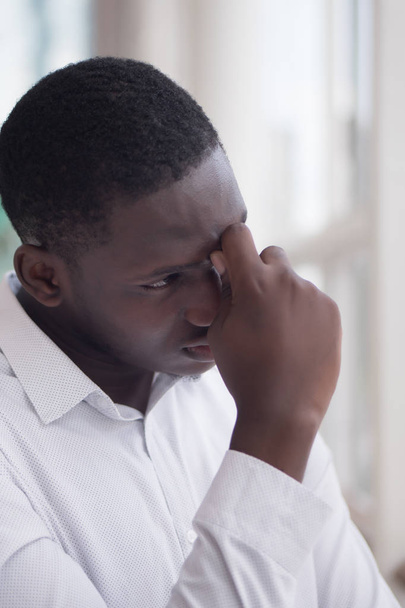 retrato de hombre negro enfermo estresado con dolor de cabeza; hombre africano enfermo sufre de dolor de cabeza, vértigo, mareo, migraña, estrés, depresión, concepto de resaca; modelo de hombre africano adulto
 - Foto, imagen