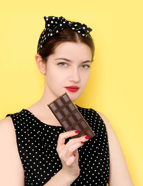 Portrait of young woman with chocolate bar - 写真・画像