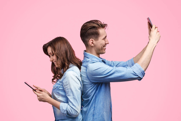 Young couple using digital devices - Zdjęcie, obraz