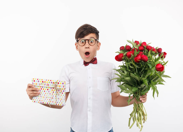 Shocked boy with present and flowers - Фото, изображение