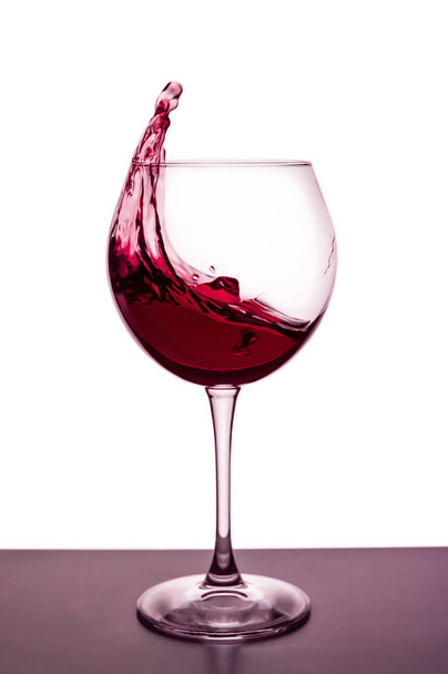 splashes of red wine in a wineglass - still life on the theme of drinks - Fotoğraf, Görsel