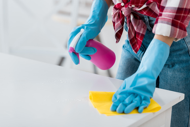 cropped view of african american woman cleaning table in blue rubber gloves - Фото, зображення