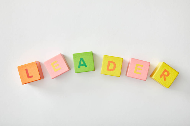 top view of leader lettering made of multicolored cubes on white background - Foto, Imagem