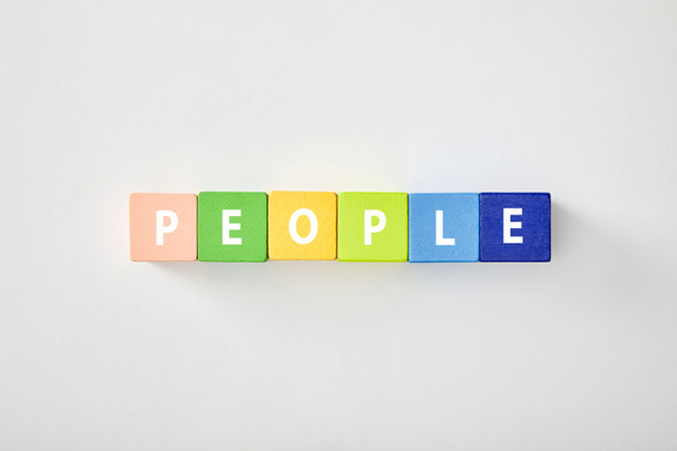 felülnézet emberek betűkkel készült színes kocka, fehér háttér - Fotó, kép