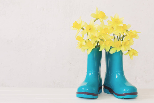 rubber boots and spring flowers on white background - Foto, Bild