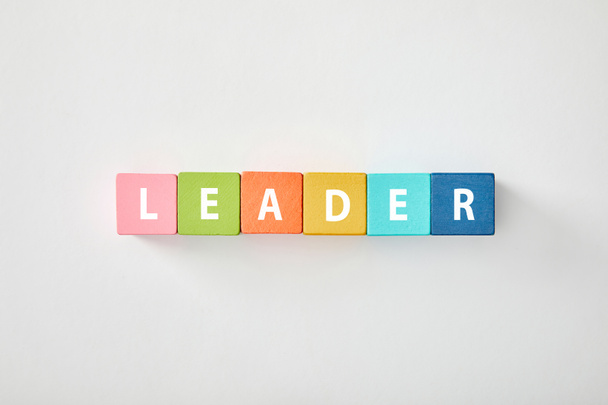 top view of leader lettering made of multicolored blocks on grey background - Fotografie, Obrázek