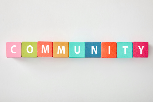 top view of community lettering made of multicolored cubes on grey background - Photo, Image
