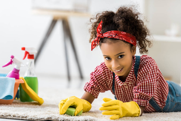 adorable alfombra de limpieza infantil afroamericana en guantes de goma amarillos
 - Foto, Imagen