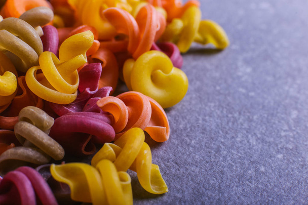 Multicolored macaroni an unusual form with natural vegetable dyes. Background macro close up. - Фото, зображення