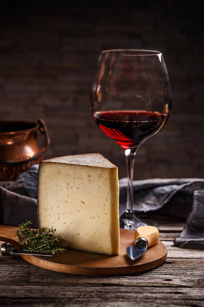 Glass of red wine and cheese still life on wooden background - Foto, Bild