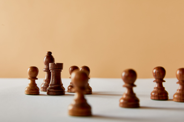 selective focus of wooden chess on white table and beige background - Zdjęcie, obraz
