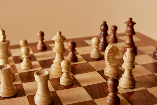 selective focus of chess on chess board and beige background - Fotó, kép