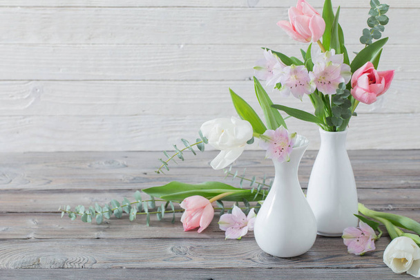 spring flowers in white vase on white wooden background - Photo, Image