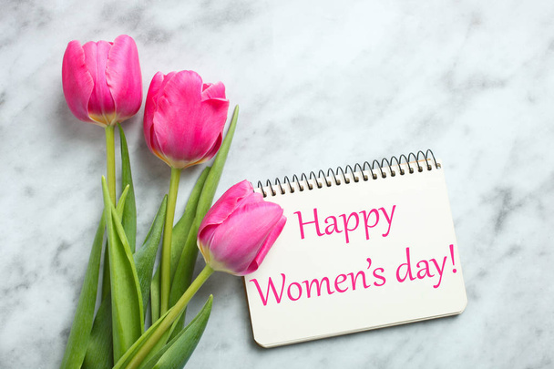 Bouquet of beautiful pink tulips and notebook on marble background. Concept International Women's Day, March 8. Top view, copy space. - Photo, Image