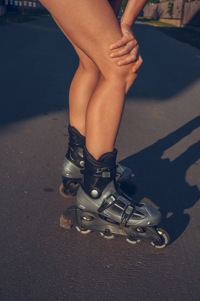 teenage girl rollerblading on the street on the road in the countryside on a summer evening at sunset close-up of a foot with a copy space - Zdjęcie, obraz