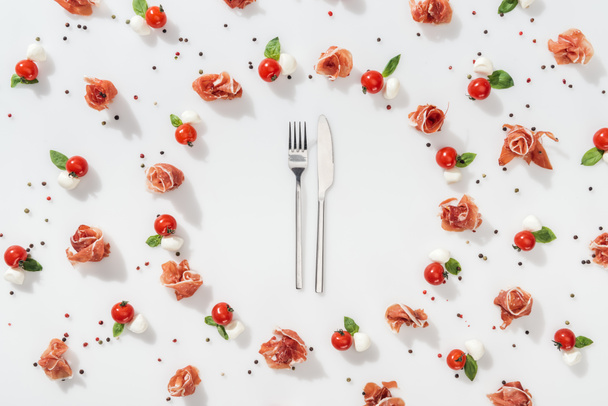 flat lay of fork and knife near tasty organic food on white background - Zdjęcie, obraz