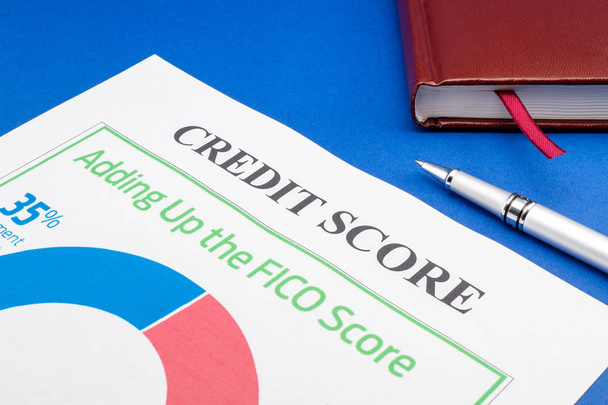 Kreditbewertungsbericht mit Stift und Notizblock auf blauem Tisch. - Foto, Bild