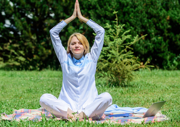 Woman relaxing practicing meditation. Every day meditation. Reasons you should meditate every day. Find minute to relax. Clear your mind. Girl meditate on rug green grass meadow nature background - Фото, изображение