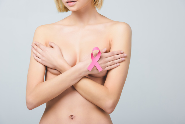 vista recortada de una joven mujer desnuda con cinta rosa para el conocimiento del cáncer de mama, aislada en gris
 - Foto, imagen