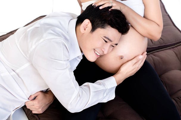 Man listening to his pregnant wifes tummy - Zdjęcie, obraz