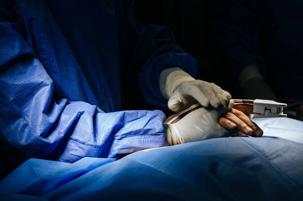 close up view of doctor or surgeon touching patient hand encouragement for support before performing surgical in operation room at hospital, emergency case, surgery, medical technology concept - 写真・画像