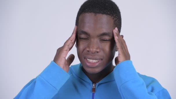 Face of young stressed African man having headache - Felvétel, videó