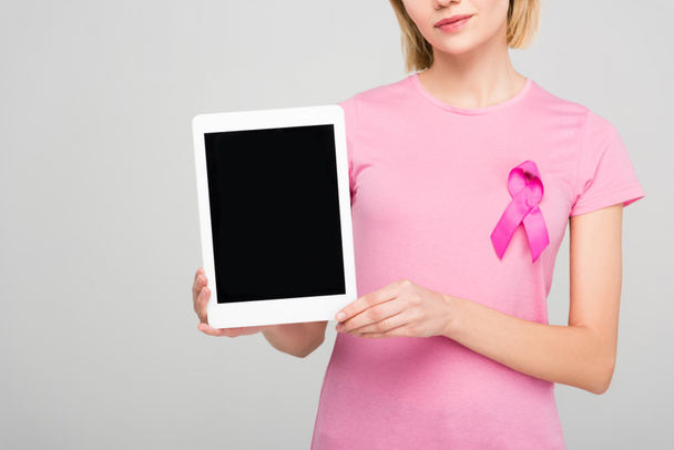 rajattu näkymä tyttö vaaleanpunainen t-paita rintasyöpä tietoisuutta nauha tilalla tabletti tyhjä näyttö, eristetty harmaa
 - Valokuva, kuva