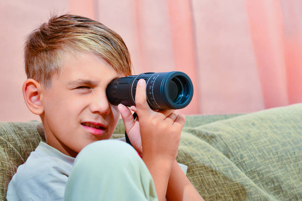 O menino olha em um monóculo
 - Foto, Imagem