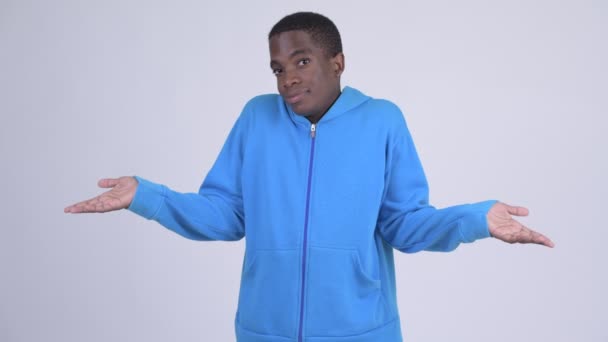 Studio shot of young handsome African man wearing blue hoodie against white background - Πλάνα, βίντεο