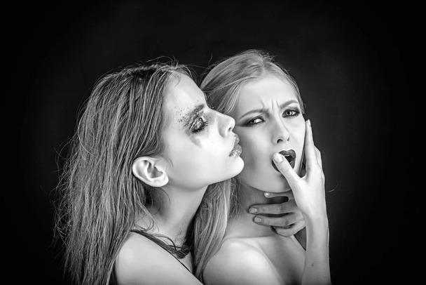 Two beautiful girls stand in a studio. One is blond, and one is brunette - Foto, afbeelding