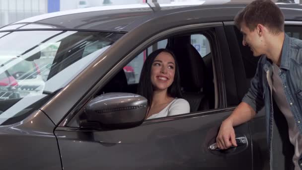 Gyönyörű nő ül egy új autó, márkakereskedés, beszélt a barátja - Felvétel, videó